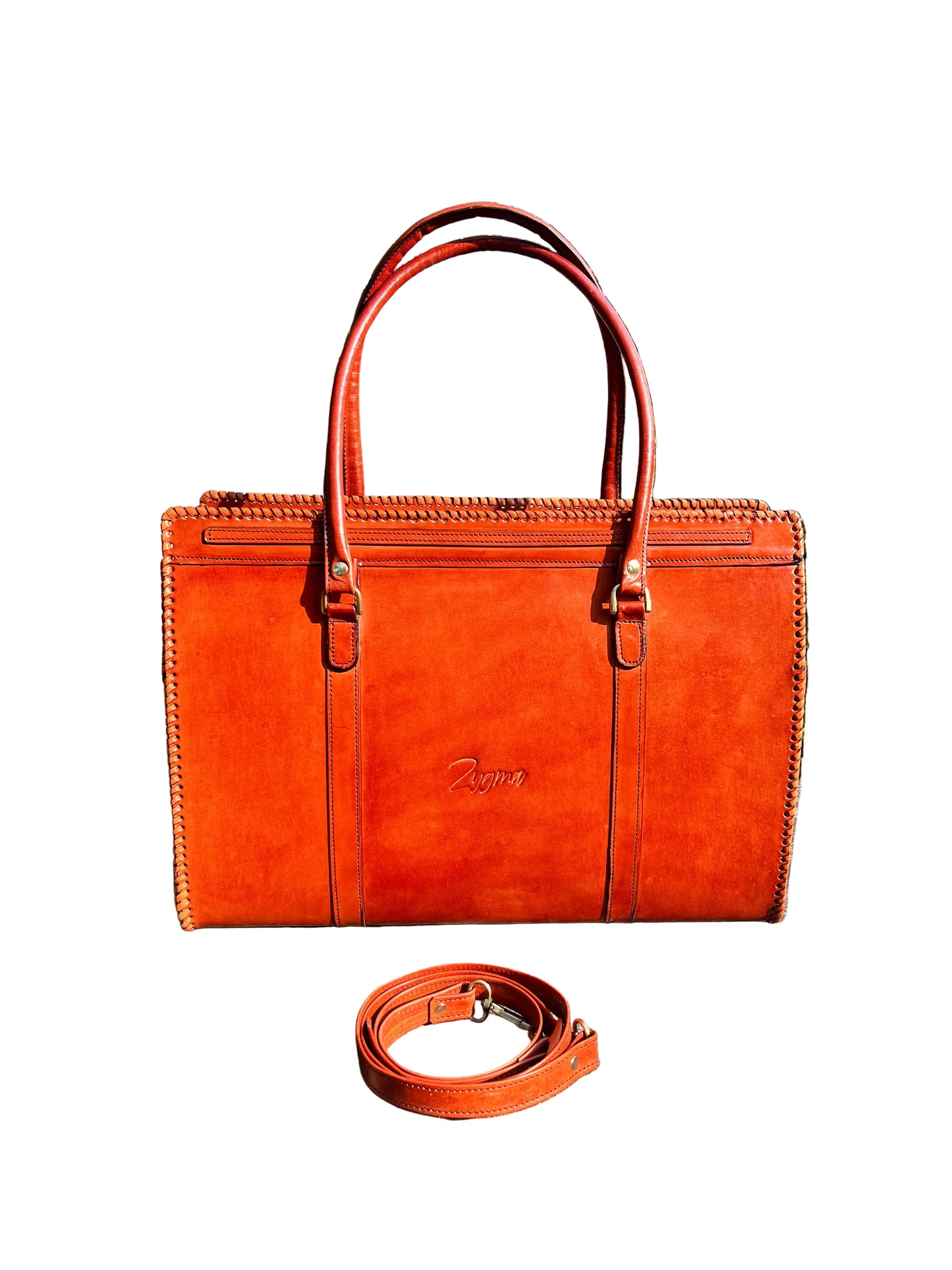 Orange leather briefcase on a stone surface with trees in the background