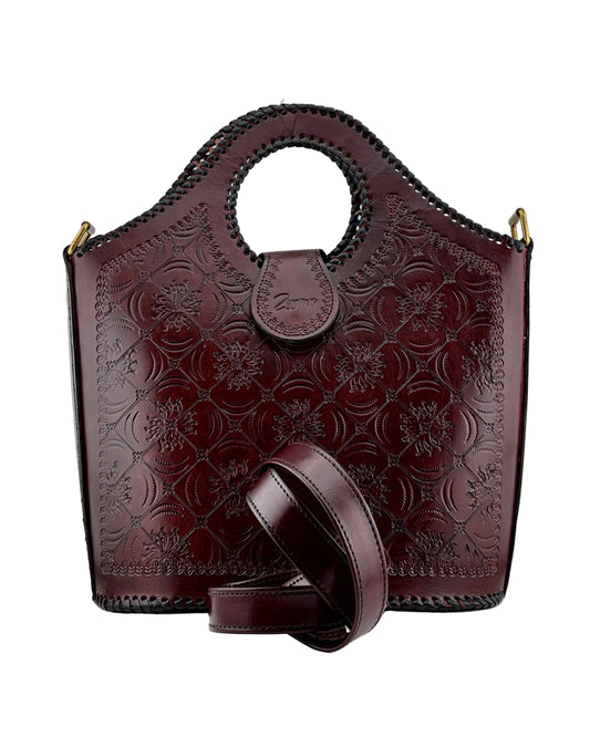 Brown leather handbag with floral embossing on a white background