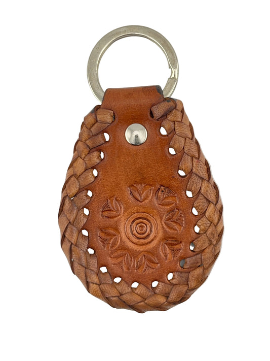 Brown leather keychain with braided design and embossed patterns on a light gray background