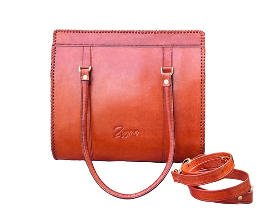 Brown leather handbag with a strap on a white background
