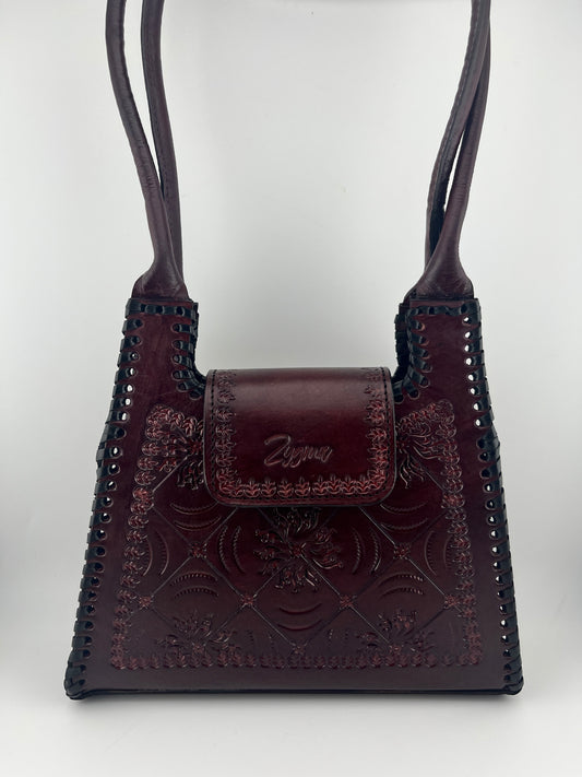 Brown leather strap with intricate designs on a white background