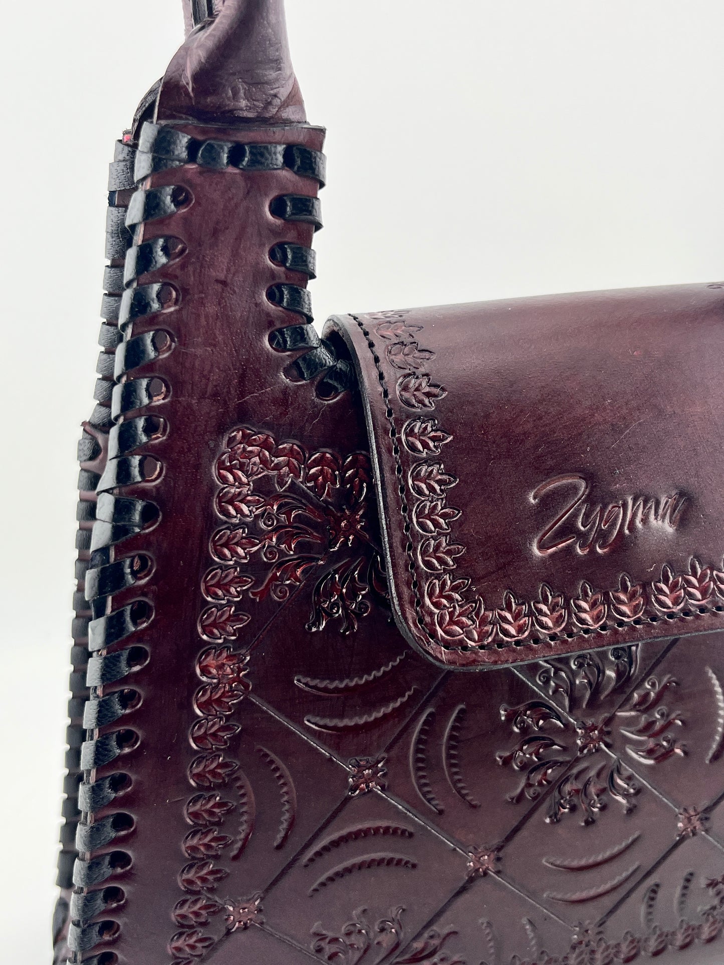 Close-up of a brown leather boot with intricate embossing and 'Zegna' branding.