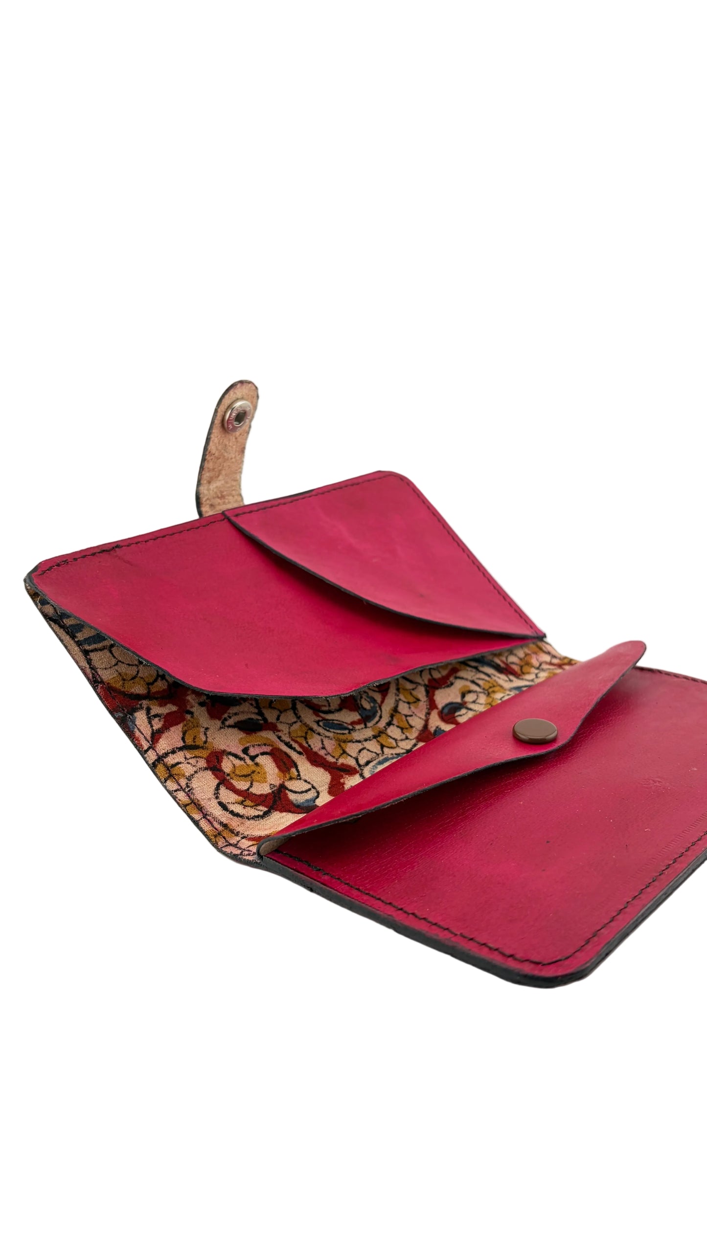 A red leather wallet shown open on a light gray background, featuring a patterned interior lining with gold, brown, and red paisley designs and a small gold snap button closure.
