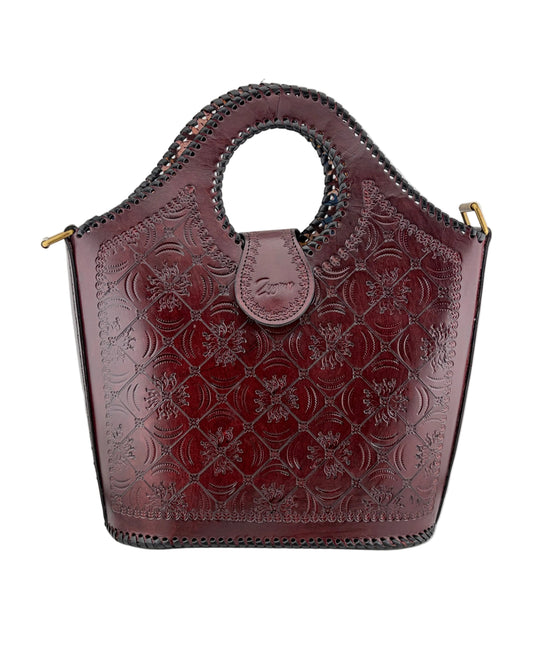 Brown leather handbag with floral embossing on a white background